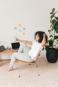 A Woman Sitting on a Chair and Holding a Tumbler